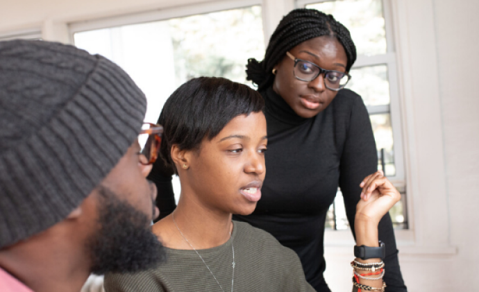 Three people talking about something, probably work