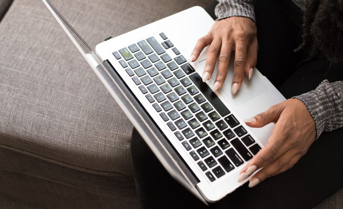 Image of someone on their laptop, only visible is the laptop and two hands